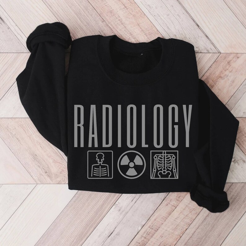 May include: Black sweatshirt with the word "RADIOLOGY" printed in grey, and three grey icons below: a skeleton, a radiation symbol, and a skeleton x-ray.