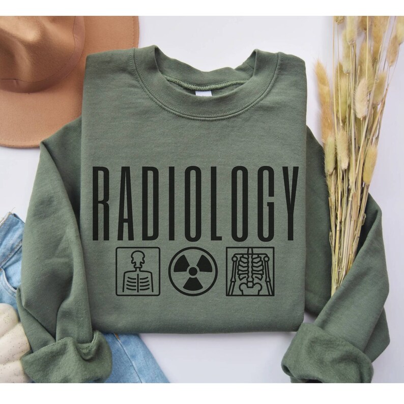 May include: A green sweatshirt with the word "RADIOLOGY" printed in black. The word is surrounded by three black icons: a skeleton, a radiation symbol, and an x-ray image of a skeleton.