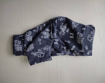 May include: A pair of dark gray pants featuring a white line-art pattern of construction vehicles, traffic signs, and the text BEEP BEEP. The fabric has a folded waistband and cuffs, showcasing a repeating graphic design of trucks and cranes.