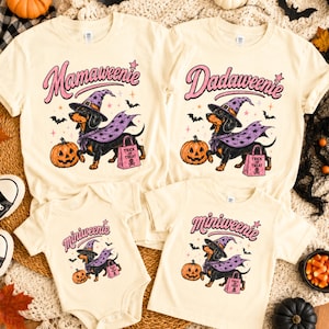 May include: Four cream-coloured shirts and a bodysuit featuring a graphic of a dachshund wearing a purple witch hat and cape, holding a pink trick-or-treat bag. The text reads Mamaweenie, Dadaweenie, and Miniweenie with small stars, bats, and pumpkins.