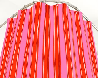 Könnte beinhalten: Ein Duschvorhang mit vertikalen Streifen in Rosa und Rot, mit dünnen weißen Linien. Der Vorhang hängt an einer gebogenen Metallstange. Das Design ist kräftig und farbenfroh.
