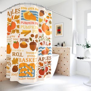 May include: A shower curtain with a seasonal autumn design. The curtain displays illustrations of pumpkins, apples, acorns, and leaves in orange, yellow, and brown hues. Text includes phrases like "Pumpkin Pie" and "Basket of Bread".