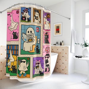 Op de afbeelding: Een kleurrijk douchegordijn met Halloween-thema met cartoongeesten en zwarte katten in postzegelontwerpen. Het gordijn heeft een roze, blauw en groen kleurenschema met de tekst "Spooky News". Het ontwerp bevat vleermuizen, een discobal en een heksenhoed.