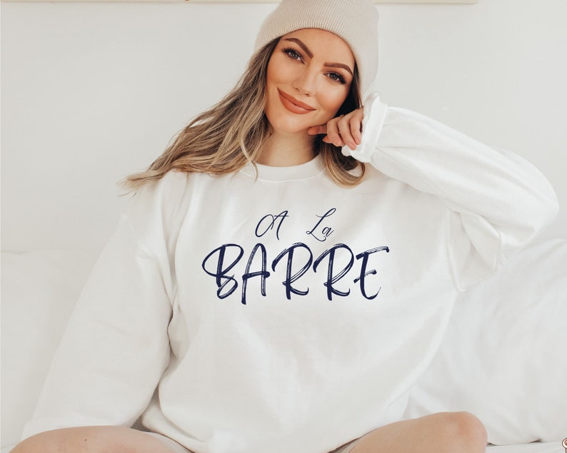 May include: White sweatshirt with a navy blue graphic that says "A La Barre" in a cursive font.