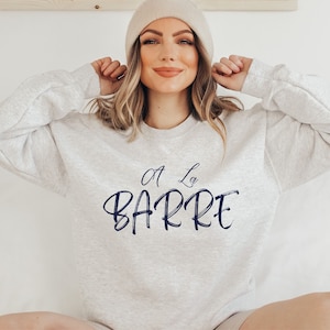 May include: A gray sweatshirt with the text "A La Barre" in navy blue lettering.
