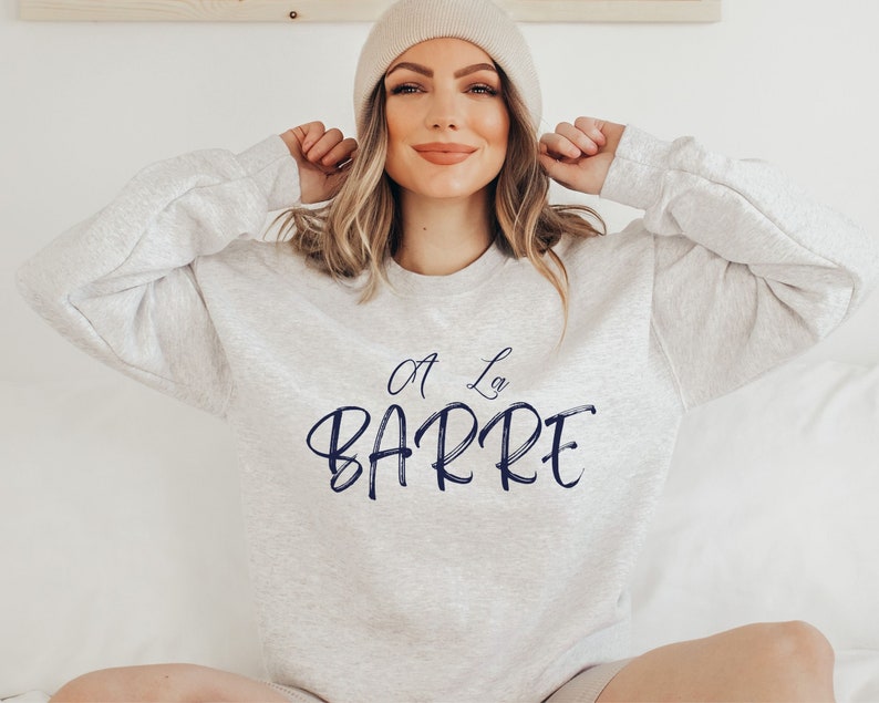 May include: A gray sweatshirt with the text "A La Barre" in navy blue lettering.