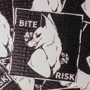 May include: Black and white sticker featuring a stylized fox head with the text "BITE RISK". The background has a repeating pattern of "CAUTION" warnings. The fox has sharp teeth and a menacing expression.