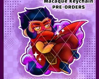 May include: A digital illustration of a stylized character with dark hair and yellow eyes, wearing a red scarf and outfit, surrounded by purple clouds and sparkles. The text reads Macaque Keychain PRE-ORDERS and Mythical Corner Shop.
