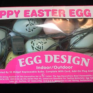 May include: A pink box with 10 Happy Easter Egg Lites. The lights are shaped like eggs with a chick and duck cutout design. The box says "Egg Design" and "Indoor/Outdoor".