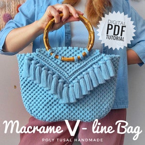 以下が含まれることがあります： V字型のデザインとフリンジのトリムが付いた薄い青色のマクラメバッグ。バッグには木製のハンドルが付いており、「Macrame V-line Bag」とラベル付けされています。