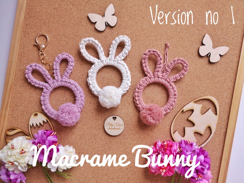 Pink macrame rabbits pendants with solid ears at cork board, next to flowers, Easter plywood eggs, butterflies. White Macrame Bunny Title. Version no 1 in the right top corner.