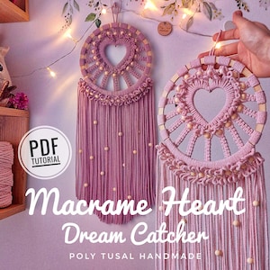 Pode incluir: Dois apanhadores de sonhos de macramé rosa com aros de madeira e desenhos de coração. Os apanhadores de sonhos têm contas e franjas. O texto "Macrame Heart Dreamcatcher" está escrito abaixo dos apanhadores de sonhos.