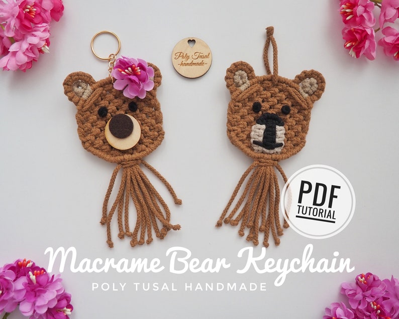 May include: Two handmade macrame bear keychains. One bear has a pink flower and a wooden nose. The other bear has a black and beige muzzle. Both have brown fringe and are on a white surface. The text "Macrame Bear Keychain" is visible.