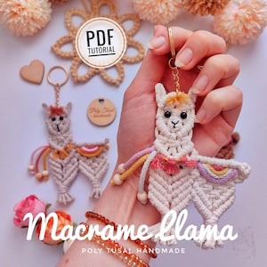 Puede incluir: Un llavero de llama de macramé hecho de cuerda color crema, con una pequeña silla de montar de colores del arcoíris, borlas rosas y cuentas de madera. La llama tiene ojos negros y una anilla de metal dorado. El texto dice PDF TUTORIAL y Macrame llama.