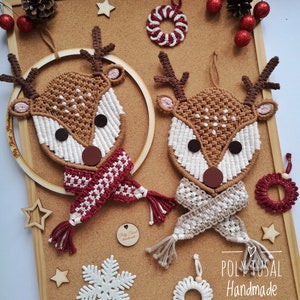 May include: Two brown and white string art reindeer with red and white scarves and brown antlers. The reindeer are hanging on a cork board with other Christmas decorations, including a snowflake, stars, and a red and white wreath.