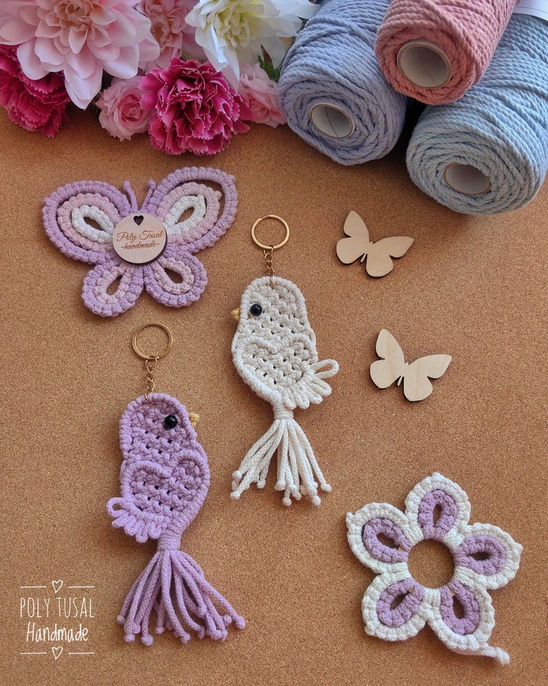 May include: A selection of handmade macrame items, including a butterfly, bird keyrings, and a flower coaster in purple and white. Wooden butterfly shapes and spools of pink and blue yarn are also present. The Poly Tusal Handmade logo is visible.