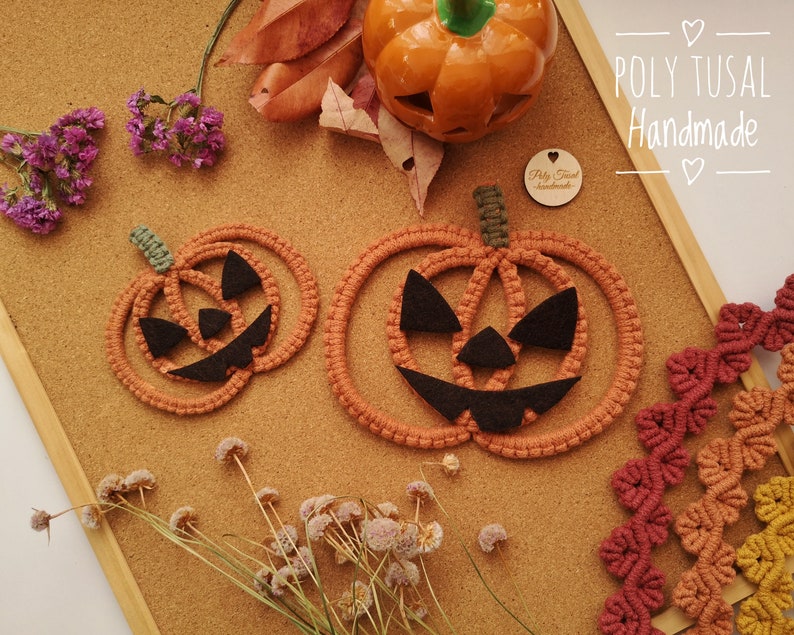 May include: Two orange crocheted pumpkin decorations with black felt faces. The pumpkins are on a cork board with autumn leaves and a small wooden sign that says "POLY TUSAL Handmade".