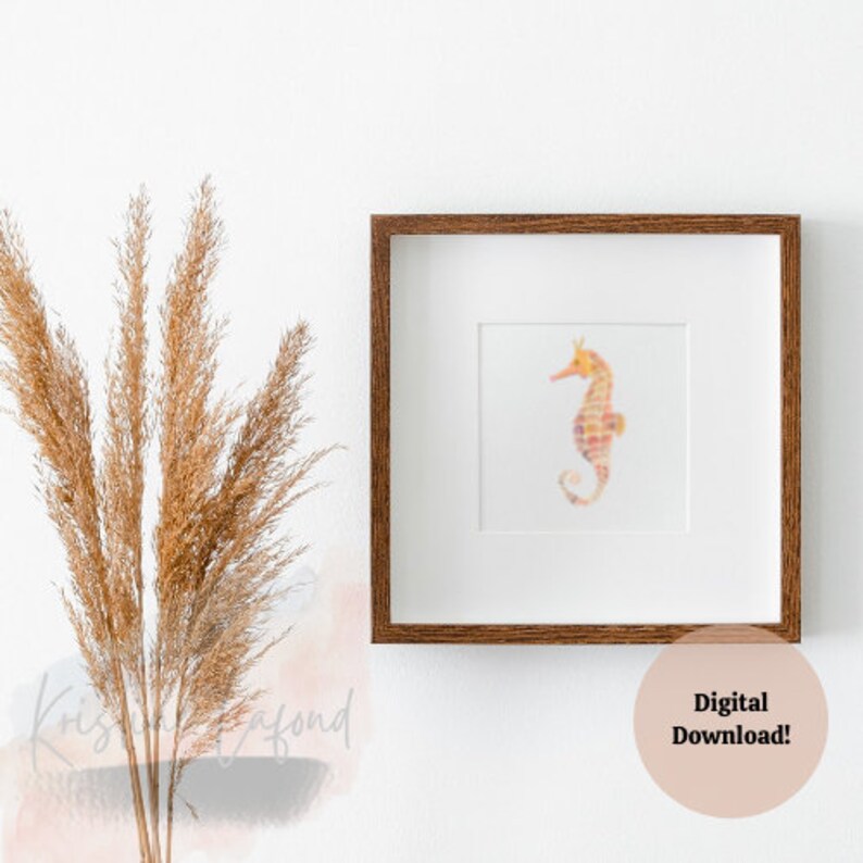 Puede incluir: Una impresi&oacute;n enmarcada con un caballito de mar en acuarela en tonos naranja, rosa y amarillo. El caballito de mar est&aacute; centrado en un passe-partout blanco dentro de un marco cuadrado de madera marr&oacute;n oscuro. El texto "Digital Download!" est&aacute; en un c&iacute;rculo rosa.