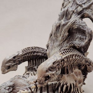 May include: A detailed, off-white sculpture of a creature with a skeletal design. The sculpture features a textured surface, with prominent rib-like structures, skulls, and a large, ornate back piece. The overall design suggests a fantasy or horror theme.
