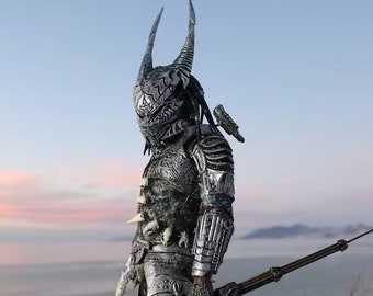 May include: A detailed silver-colored costume with a horned helmet and intricate armor. The figure holds a long, thin weapon. The background features a mountain landscape with a sunset and the text "Printed Wicked".