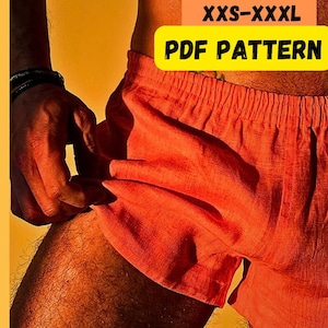 May include: Close-up of orange linen shorts. Text on the image reads "LINEN SHORTS XXS-XXXL PDF PATTERN BEGINNER FRIENDLY". The shorts are a vibrant orange color and appear to be made of a lightweight fabric.