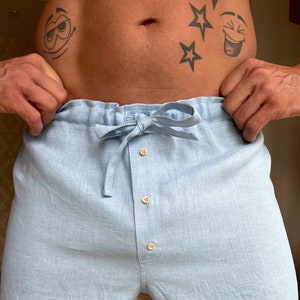 K&ouml;nnte beinhalten: Hellblaue Leinenhose mit Kordelzugbund und Knopfleiste. Die Hose hat eine lockere Passform und ist perfekt zum Entspannen zu Hause.