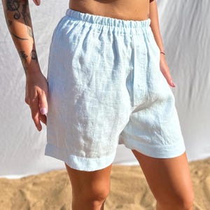 Pu&ograve; includere: Pantaloncini azzurri con elastico in vita e vestibilit&agrave; rilassata. Il capo &egrave; realizzato in un tessuto testurizzato con dettagli di trama visibili e termina con un orlo dritto sopra il ginocchio, offrendo un design semplice e funzionale.