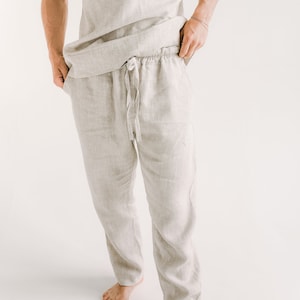 Op de afbeelding: Een licht beige linnen broek met een trekkoord. De broek is losjes gesneden en heeft een ontspannen, casual look.