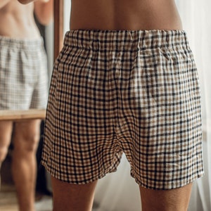Op de afbeelding: Een bruin en wit geruite broek met een trekkoord.