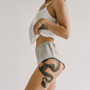 Pu&ograve; includere: Un top in lino chiaro con spalline sottili e pantaloncini abbinati. I pantaloncini sono di colore grigio chiaro con elastico in vita. L'outfit &egrave; realizzato in un tessuto morbido e traspirante, perfetto per la stagione calda.