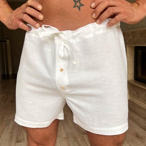 K&ouml;nnte beinhalten: Wei&szlig;e Leinenhose mit Kordelzugbund und Knopfleiste. Die Hose ist locker geschnitten und hat eine lockere Passform.