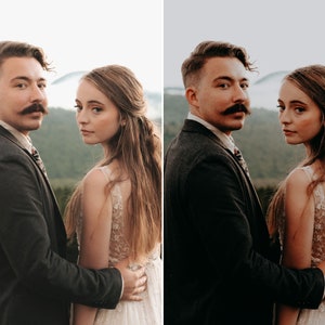 May include: A person with a mustache wearing a dark charcoal blazer and a patterned tie standing next to a person with long brown hair wearing a white sleeveless dress with intricate floral embroidery and a sheer bodice overlay.