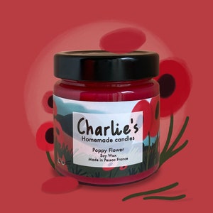 Peut inclure: Un pot en verre rouge avec un couvercle noir et une étiquette blanche qui dit "Charlie's Homemade Candles Poppy Flower Soy Wax Made in Pessac France". Le pot est entouré de fleurs de pavot rouges.