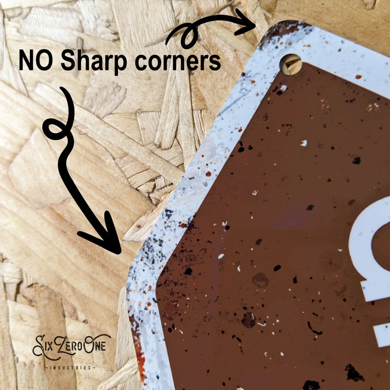 May include: A brown metal sign with white lettering that reads "Campsite". The sign has a distressed, vintage look with white paint splatters and a hole at the top for hanging. The sign has rounded corners.