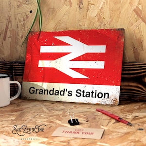 May include: Red and white metal sign with a white railway symbol and the text "Grandad's Station".