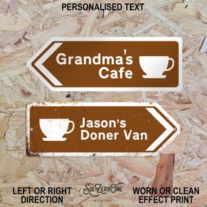May include: Two brown and white directional signs with white arrows pointing left and right. The top sign says "Grandma's Cafe" with a white coffee cup icon. The bottom sign says "Jason's Doner Van" with a white coffee cup icon. The signs have a worn, rustic look.