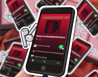 May include: A white sticker with a black outline of a smartphone playing music. The screen displays the text "Beats to Contemplate Eternity to" and a list of songs: "Show Your Fangs", "A Thousand Years (The Twilight Saga)", and "Fake Your Death".