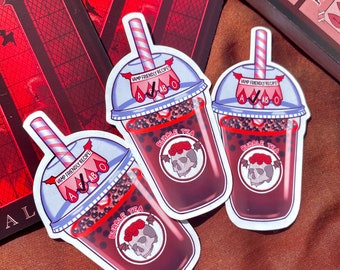 Puede incluir: Tres pegatinas de una bebida de té de burbujas con temática de vampiros. Cada pegatina presenta una pajita a rayas rojas y blancas, una taza transparente con perlas de tapioca negras y un líquido rojo. La taza tiene una etiqueta blanca con el texto "VAMP FRIENDLY RECIPE" y una calavera con rosas rojas y alas de murciélago. El texto "BUBBLE TEA" está escrito en un círculo alrededor de la calavera.