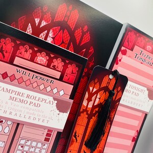 Puede incluir: Un conjunto de art&iacute;culos de papeler&iacute;a con tem&aacute;tica de Vampire: The Masquerade. El conjunto incluye una libreta de notas, una libreta de lista de tareas y un marcap&aacute;ginas. Todos los art&iacute;culos presentan un dise&ntilde;o de vitral con un esquema de color rojo y negro. La libreta de notas est&aacute; etiquetada como "Vampire Roleplay Memo Pad" y es compatible con las ediciones 5&ordf; y 20&ordf; del juego. La libreta de lista de tareas est&aacute; etiquetada como "To-Do Tonight" y el marcap&aacute;ginas tiene un borla negra.
