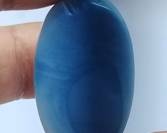 May include: A smooth, oval-shaped blue gemstone with white streaks and swirls.