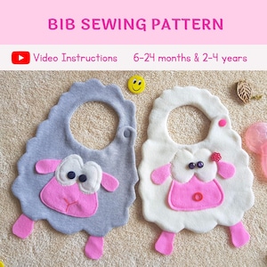 May include: Two gray and white bibs with a sheep design. The bibs have pink accents and are made of soft fabric. The bibs are for babies and toddlers. Video instructions are included.