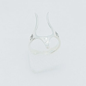 Peut inclure: Bague en argent avec deux petites pierres claires et un design unique. La bague est marqu&eacute;e du num&eacute;ro "925" sur le c&ocirc;t&eacute;.