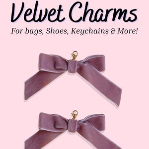 May include: Two mauve velvet bow charms with gold-colored clasps, displayed on a light pink background. The text "Velvet Charms" and "For bags, Shoes, Keychains & More!" are displayed above the bows.