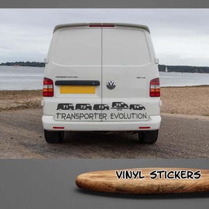 Peut inclure: Un fourgon blanc avec une silhouette noire d'un Volkswagen Transporter T1, T2, T3, T4 et T5 à l'arrière. Le texte "Transporter Evolution" est imprimé sous les silhouettes. Le fourgon est garé sur une plage avec une étendue d'eau en arrière-plan.
