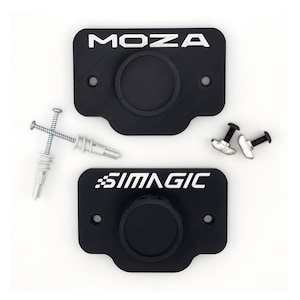 May include: Two black wall mounts with the text "MOZA" and "SIMAGIC" printed in white. The mounts have a circular cutout in the centre and are designed for mounting a camera or other device.