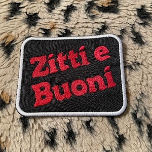 Könnte beinhalten: Schwarz-weißer Patch mit rotem Text, der "Zitti e Buoni" sagt.