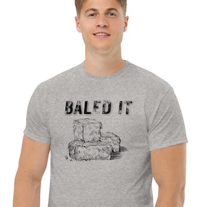 May include: A heather grey t-shirt with a black graphic of hay bales and the text "BALED IT".