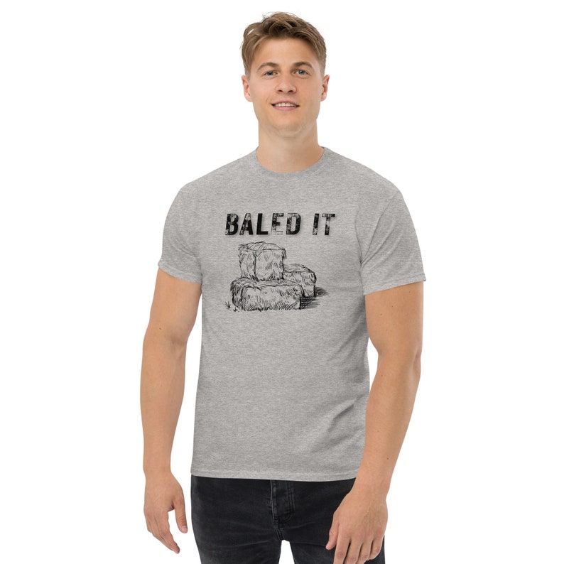 May include: A heather grey t-shirt with a black graphic of hay bales and the text "BALED IT".