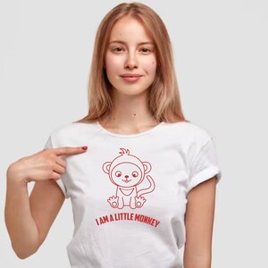 May include: A white t-shirt with a red outline of a cartoon monkey wearing a hat and the text "I AM A LITTLE MONKEY".