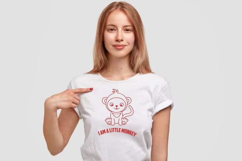 May include: A white t-shirt with a red outline of a cartoon monkey wearing a hat and the text "I AM A LITTLE MONKEY".